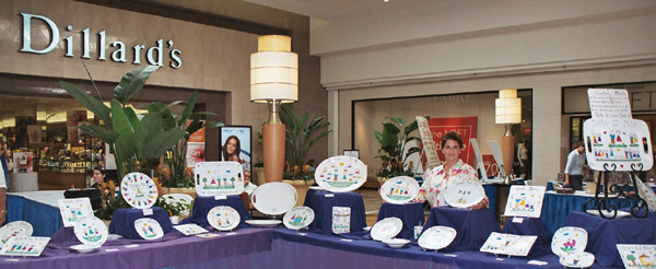 Show at Dillards - Carol Creations is the creator of hand-painted, custom crafted plates, platters, hot plates, mugs and more.  Carol Creations starts with high quality porcelain dinner and tableware that is then hand-painted.  After painting, each item is oven fired for durability.  Each figure is customized to resemble family members or friends with hair color and style, and other distinguishing characteristics.  Carol Creations custom painting makes these truly special and unique gifts for holidays, baby showers, weddings, birthdays . . . gifts for someone special anytime.  